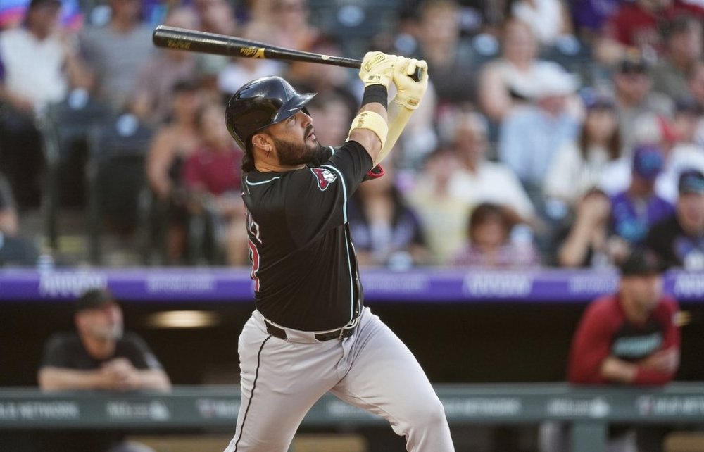 Arizona Diamondbacks' Eugenio Suárez follows the flight of his solo home run off Colorado Rockies starting pitcher Carson Palmquist in the third inning of a baseball game Saturday, June 21, 2025, in Denver. (AP Photo/David Zalubowski)