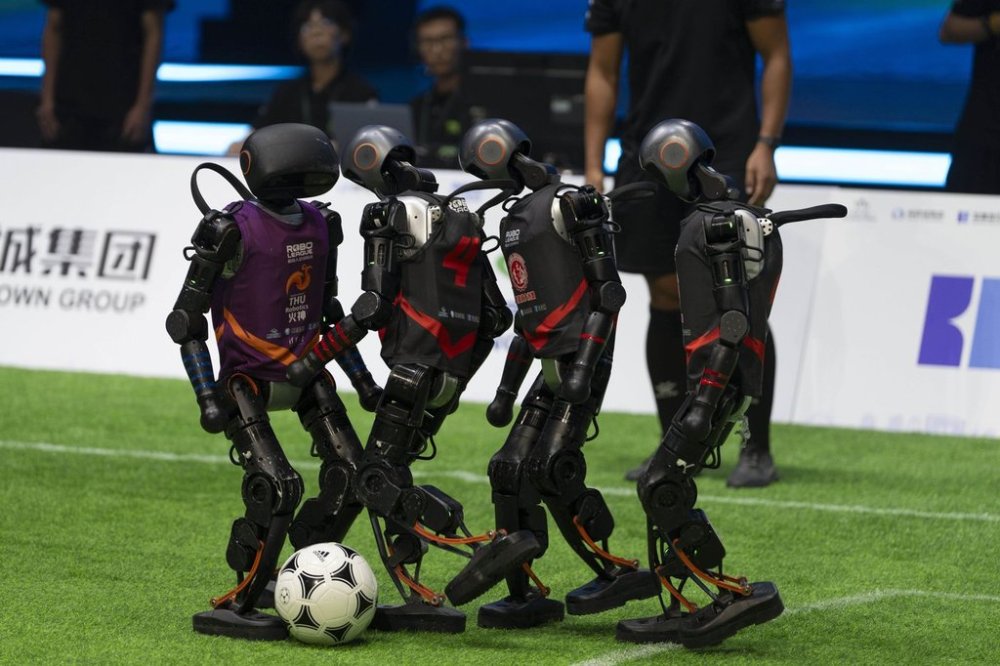 Teams compete using the T1 robots from Booster Robotics during the inaugural RoBoLeague robot soccer competition held in Beijing, Saturday, June 28, 2025. (AP Photo/Ng Han Guan)