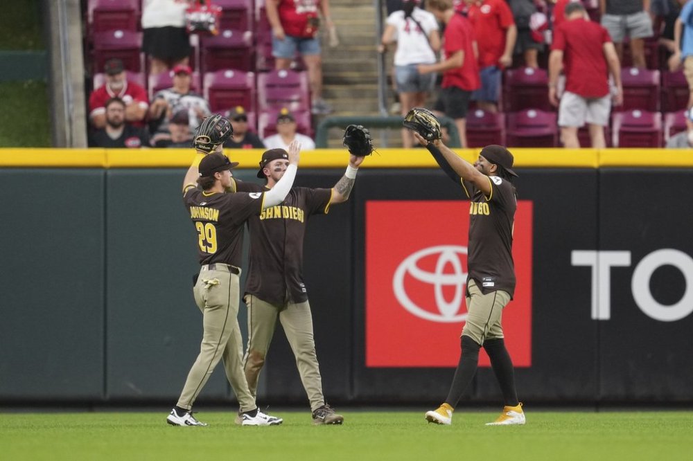 San Diego Padres' Bryce Johnson (29), Jackson Merrill, center, and Fernando Tatis Jr. celebrate following a baseball game against the Cincinnati Reds, Saturday, June 28, 2025, in Cincinnati. (AP Photo/Jeff Dean)