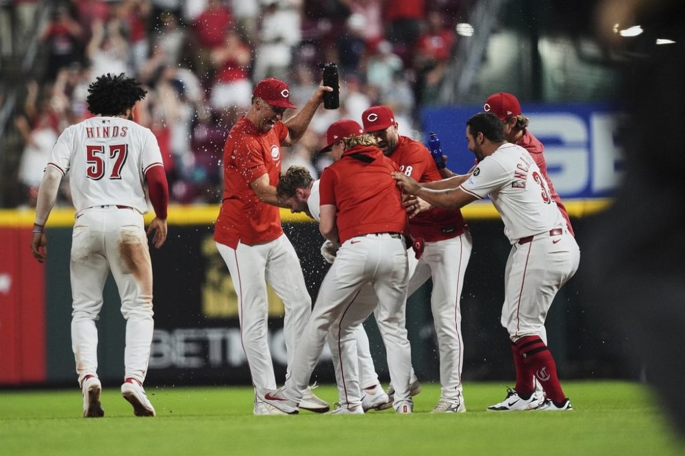 Teammates celebrate with Cincinnati Reds' Gavin Lux, center, after he hit an RBI single to score Elly De La Cruz and win the game during the eleventh inning of a baseball game against the New York Yankees, Tuesday, June 24, 2025, in Cincinnati. (AP Photo/Joshua A. Bickel)