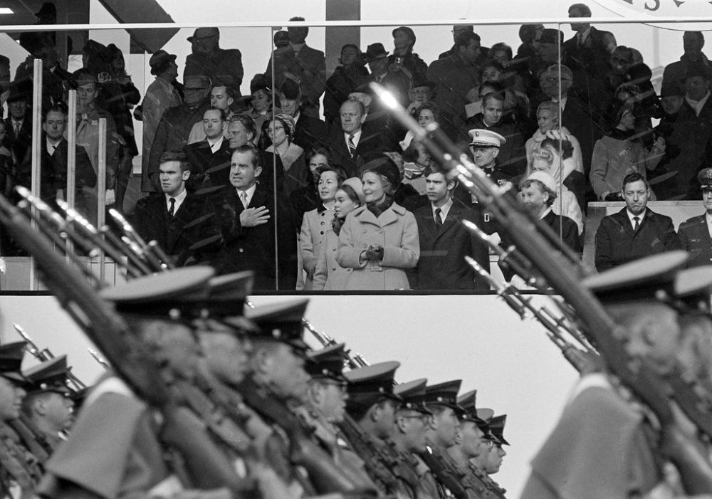 FILE - President Nixon salutes as cadets from the West Point Military Academy pass the presidential reviewing stand during the inaugural parade in Washington, D.C., Jan. 20, 1969. In the front row of the reviewing stand, from left are Doug Rogers, the President, Barbara Eisenhower, Julie Nixon Eisenhower, Pat Nixon, David Eisenhower and Mamie Eisenhower. (AP Photo, File)