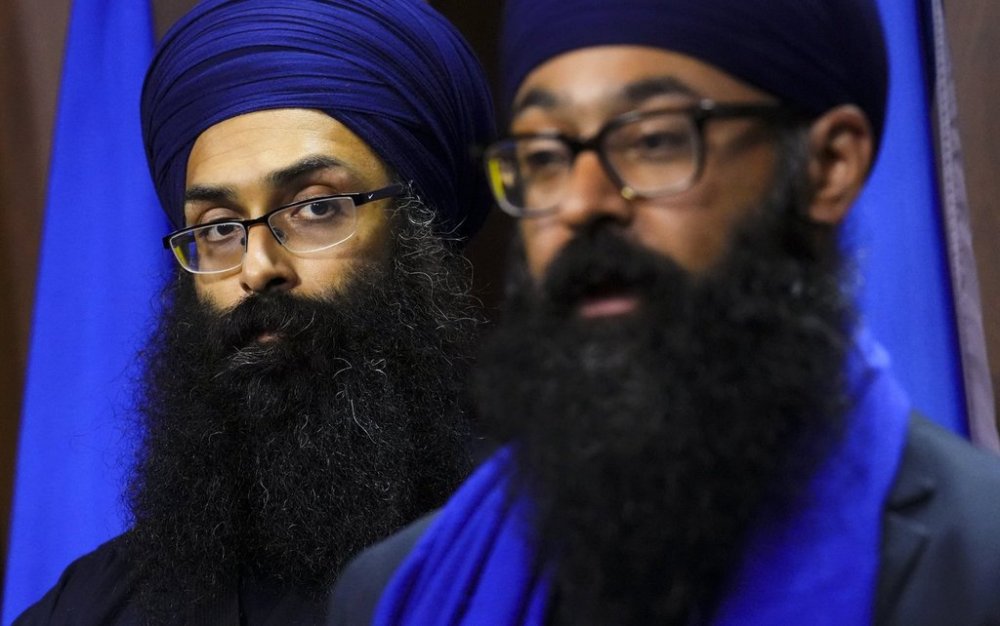 Balpreet Singh, spokesperson for the World Sikh Organization of Canada, left, looks towards Moninder Singh, spokesperson for the B.C. Gurdwaras Council and Sikh Federation Canada, as they hold a press conference on Parliament Hill in Ottawa on Thursday, June 12, 2025. THE CANADIAN PRESS/Sean Kilpatrick