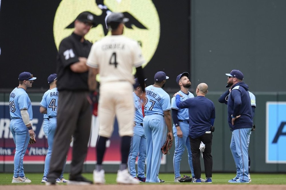 Toronto Blue Jays right-fielder Nathan Lukes (38), middle right, is looked at by a trainer after a collision with teammate second baseman Ernie Clement (22) during the sixth inning of a baseball game against the Minnesota Twins, Sunday, June 8, 2025, in Minneapolis. (AP Photo/Abbie Parr)