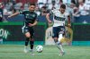 Seattle Sounders' Cristian Roldan (left) and Vancouver Whitecaps' Daniel Rios (14) vie for the ball during the first half of an MLS soccer match in Vancouver, on Sunday, June 8, 2025. THE CANADIAN PRESS/Ethan Cairns