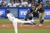 San Diego Padres' Xander Bogaerts hits a solo home run as Los Angeles Dodgers starting pitcher Yoshinobu Yamamoto, left, watches along with catcher Will Smith, during the XX inning of a baseball game Thursday, June 19, 2025, in Los Angeles. (AP Photo/Mark J. Terrill)