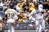Pittsburgh Pirates' Nick Gonzales, left, is greeted by Henry Davis, right, after scoring during the seventh inning of a baseball game against the St. Louis Cardinals, Wednesday, July 2, 2025, in Pittsburgh. (AP Photo/Matt Freed)