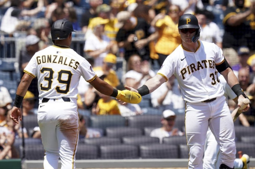 Pittsburgh Pirates' Nick Gonzales, left, is greeted by Henry Davis, right, after scoring during the seventh inning of a baseball game against the St. Louis Cardinals, Wednesday, July 2, 2025, in Pittsburgh. (AP Photo/Matt Freed)