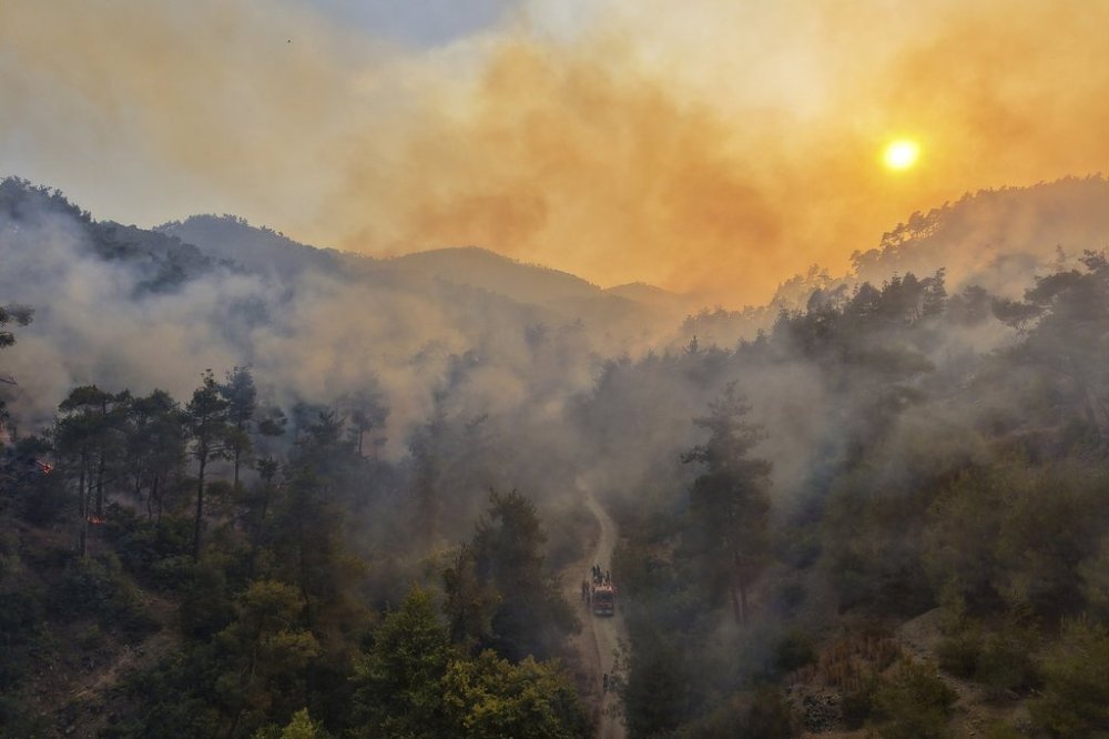 Smoke rises into the sky during a wildfirenear the town of Rabia, Syria, in the Latakia countryside, Sunday, July 6, 2025. (AP Photo/Ghaith Alsayed)