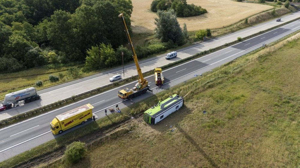 Emergency services work at the scene as the bus lies beside the A19 highway near Röbel, Germany, Friday, July 4, 2025. (Rene Schröder/NEWS5/dpa via AP)