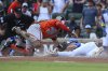 Baltimore Orioles catcher Gary Sánchez, center, tags out Atlanta Braves' Matt Olson, right, at the plate in the fourth inning of a baseball game against the Atlanta Braves, Saturday, July 5, 2025, in Atlanta. (AP Photo/Colin Hubbard)