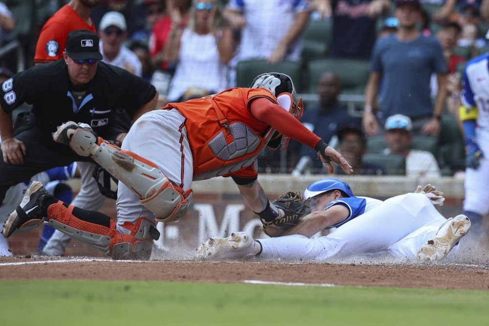 Baltimore Orioles catcher Gary Sánchez, center, tags out Atlanta Braves' Matt Olson, right, at the plate in the fourth inning of a baseball game against the Atlanta Braves, Saturday, July 5, 2025, in Atlanta. (AP Photo/Colin Hubbard)