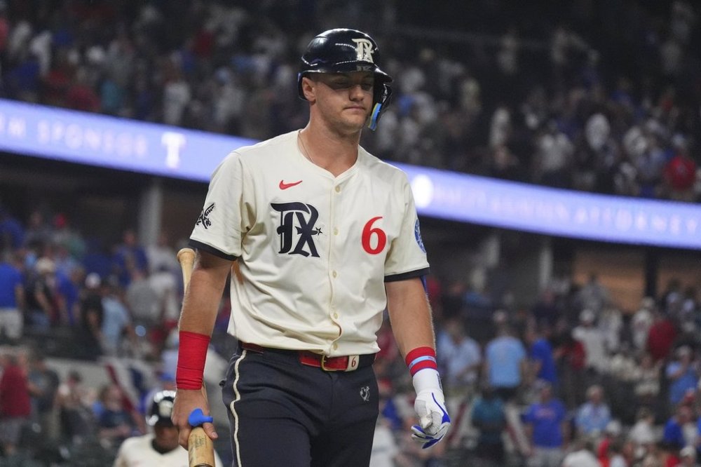 Texas Rangers' Josh Jung walks to the dugout after striking out, ending the 12th inning of a baseball game against the Seattle Mariners, Friday, June 27, 2025, in Arlington, Texas. (AP Photo/LM Otero)