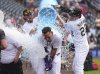 Colorado Rockies' Orlando Arcia, center, is doused after hitting a walkoff single to drive in two runs by Sam Hilliard, back left, and Mickey Moniak after the Rockies' victory over the San Francisco Giants in a baseball game Thursday, June 12, 2025, in Denver. (AP Photo/David Zalubowski)