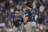 Seattle Mariners relief pitcher Matt Brash (47) and catcher Cal Raleigh (29) celebrate after a baseball game against the Minnesota Twins, Tuesday, June 24, 2025, in Minneapolis. (AP Photo/Abbie Parr)