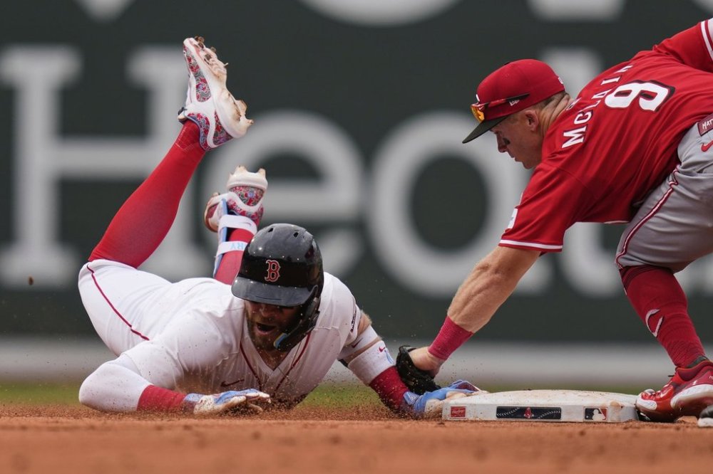 Boston Red Sox's Trevor Story, left, is tagged out by Cincinnati Reds second baseman Matt McLain (9) after over running the base on his RBI double during the eighth inning of a baseball game, a continuation of a game the night before which was suspended due to rain, Wednesday, July 2, 2025, at Fenway Park, in Boston. (AP Photo/Charles Krupa)