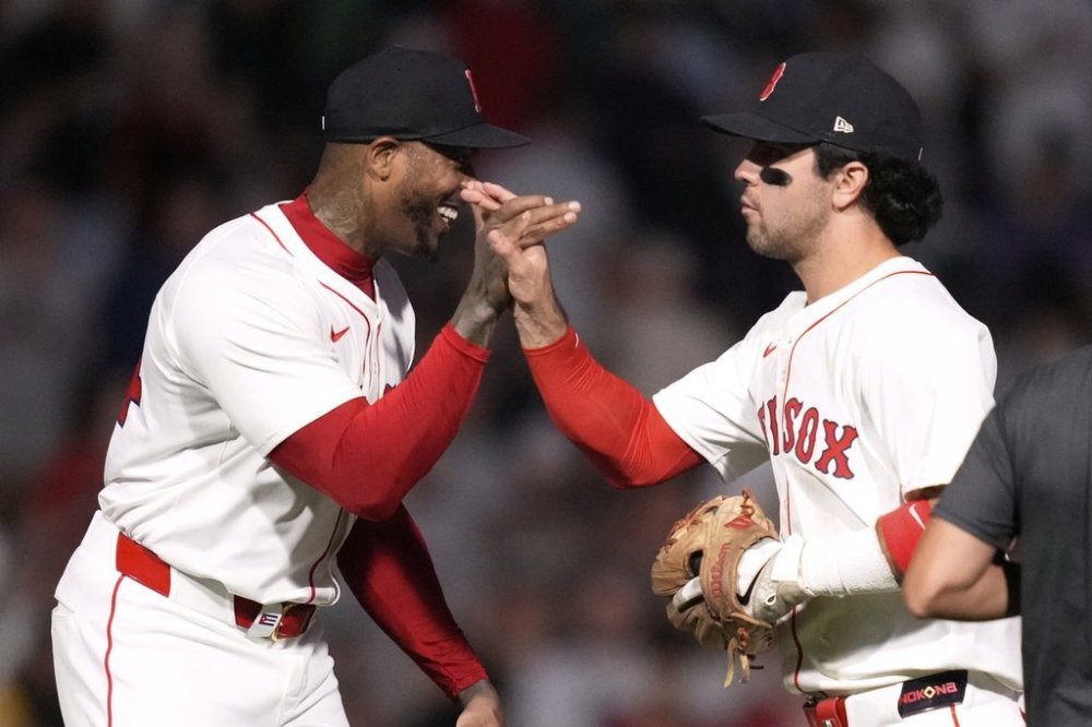 Boston Red Sox third baseman Marcelo Mayer, right, celebrates with pitcher Aroldis Chapman after defeating the Tampa Bay Rays following a baseball game at Fenway Park, Wednesday, June 11, 2025, in Boston. (AP Photo/Charles Krupa)