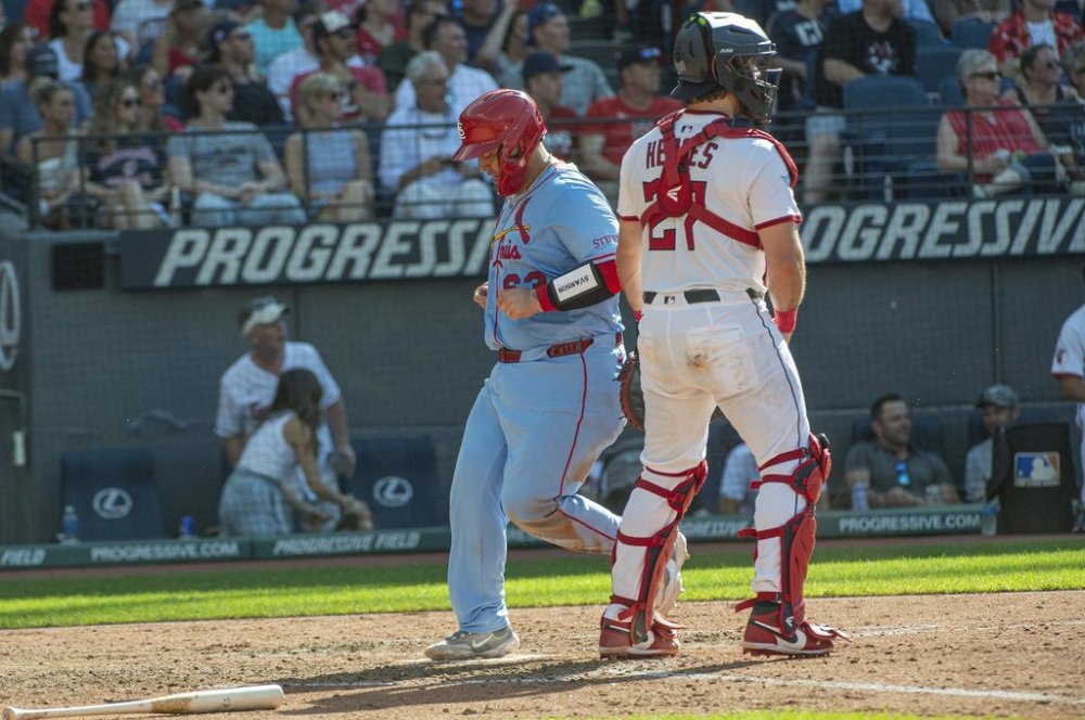 St. Louis Cardinals' St. Louis Cardinals' Yohel Pozo, left, scores on a sacrifice fly by Brendan Donovan as Cleveland Guardians' Austin Hedges stands by during the sixth inning of a baseball game, Saturday, June 28, 2025, in Cleveland. (AP Photo/Phil Long)