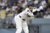 Los Angeles Dodgers' Shohei Ohtani takes a hit by pitch during the third inning of a baseball game against the San Diego Padres in Los Angeles, Tuesday, June 17, 2025. (AP Photo/Kyusung Gong)