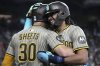 San Diego Padres' Fernando Tatis Jr., right, celebrates with Gavin Sheets (30) after scoring against the Arizona Diamondbacks on a double hit by Luis Arraez in the fifth inning during a baseball game, Sunday, June 15, 2025, in Phoenix. (AP Photo/Rick Scuteri)