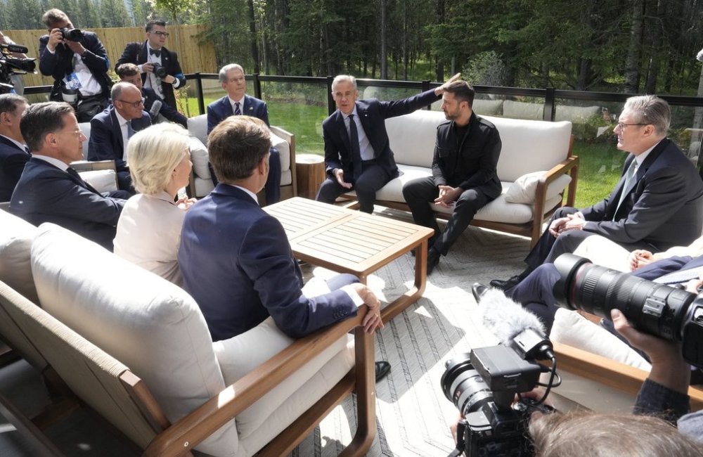 Prime Minister Mark Carney speaks with leaders as they gather on a patio before a working session at the G7 Summit in Kananaskis, Alta., on Tuesday, June 17, 2025. THE CANADIAN PRESS/Adrian Wyld