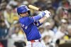Texas Rangers' Kyle Higashioka (11) hits an RBI single during the eighth inning of a baseball game against the San Diego Padres Saturday, July 5, 2025. (AP Photo/Denis Poroy)