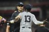 New York Yankees' manager Aaron Boone takes Jazz Chisholm Jr. to the dugout after he was ejected for confronting home plate umpire Mark Wegner after being called out on strikes during the ninth inning of a baseball game against the Cincinnati Reds, Tuesday, June 24, 2025, in Cincinnati. (AP Photo/Joshua A. Bickel)