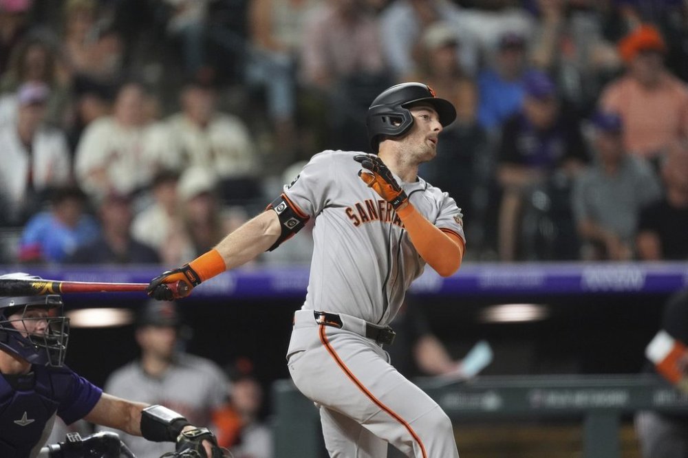 San Francisco Giants' Mike Yastrzemski singles to drive in the go-ahead run off Colorado Rockies relief pitcher Victor Vodnik in the ninth inning of a baseball game Tuesday, June 10, 2025, in Denver. (AP Photo/David Zalubowski)