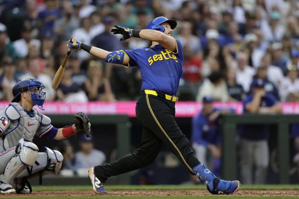 Seattle Mariners' Cal Raleigh hits a solo home run off Texas Rangers starting pitcher Kumar Rocker during the fifth inning in a baseball game Thursday, July 31, 2025, in Seattle. (AP Photo/John Froschauer)