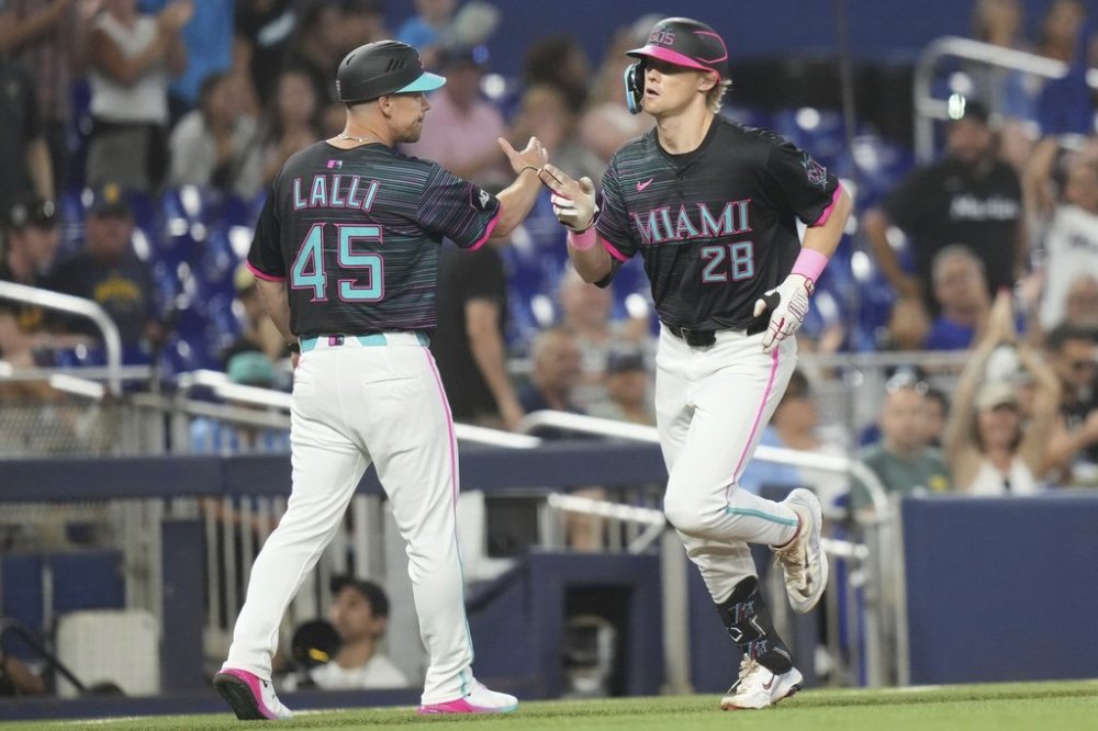 Miami Marlins' Kyle Stowers (28) passes third base coach Blake Lalli (45) after hitting a solo home run during the third inning of a baseball game against the Milwaukee Brewers, Saturday, July 5, 2025, in Miami. (AP Photo/Lynne Sladky)