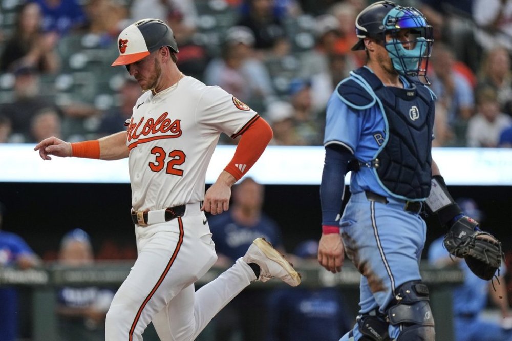 Baltimore Orioles' Ryan O'Hearn (32) scores past Toronto Blue Jays catcher Tyler Heineman, right, on a groundout hit by Ramon Urias during the fourth inning in the second baseball game of a doubleheader, Tuesday, July 29, 2025, in Baltimore. (AP Photo/Stephanie Scarbrough)