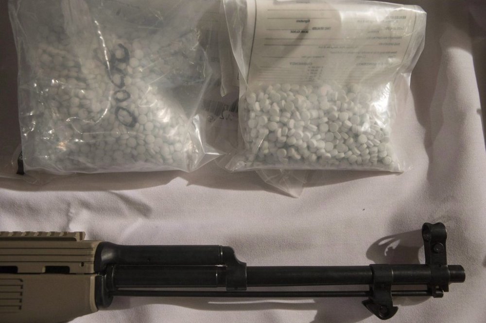 Bags containing fentanyl lie next to a firearm on a display table as Ontario Provincial Police host a news conference in Vaughan, Ont., on Thursday, Feb. 23, 2017. THE CANADIAN PRESS/Chris Young