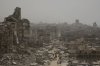 People walk along a street lined with destroyed buildings following Israeli bombardments during the Israel-Hamas war in the Gaza Strip, Tuesday, July 29, 2025. (AP Photo/Jehad Alshrafi)