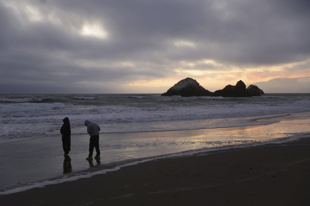 During a tsunami advisory triggered by an underwater earthquake off the coast of Russia, Gaby Lazlo and Daniel Ramirez visit Ocean Beach in San Francisco on Tuesday, July 29, 2025. (Scott Strazzante/San Francisco Chronicle via AP)