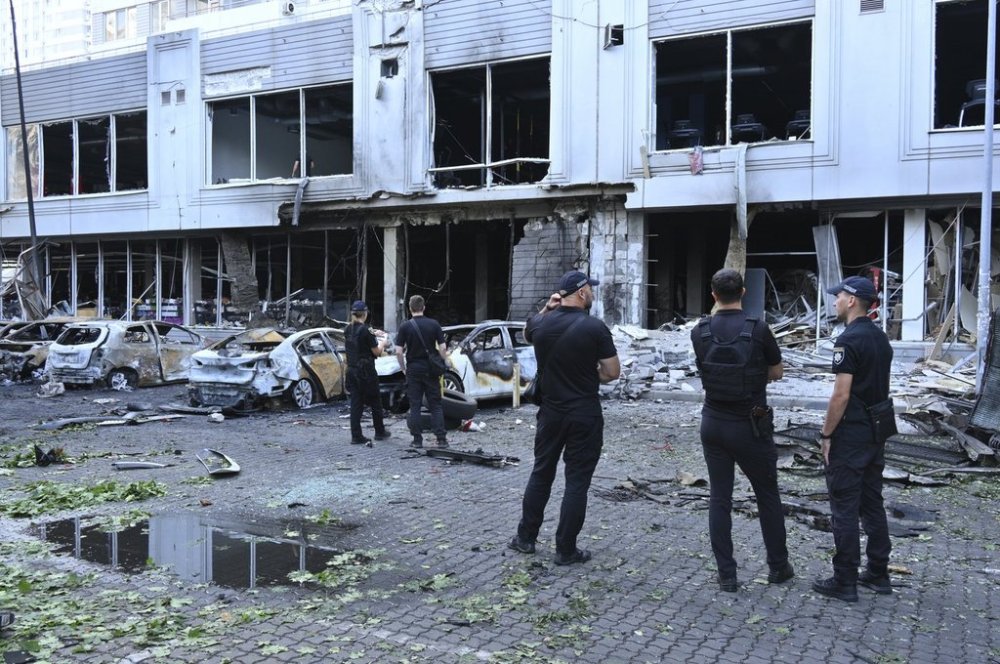 Police officers inspect damaged cars at a residential area following Russia's drone attack in Odesa, Ukraine, Tuesday, July 22, 2025. (AP Photo/Michael Shtekel)