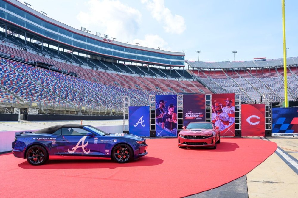 In this image provided by Bristol Moto Speedway, an Atlanta Braves, left, and Cincinnati Reds themed race cars are display at Bristol Motor Speedway, Thursday, July 31, 2025, in Bristol, Tenn., as preparations continue for the MLB Speedway Classic baseball game between the Reds and Braves on Aug. 2. (Earl Neikirk/Bristol Motor Speedway via AP