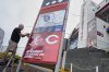Rod Bruchell installs signs outside Bristol Motor Speedway, Friday, Aug. 1, 2025, in Bristol, Tenn., the day before the MLB Speedway Classic baseball game between the Cincinnati Reds and Atlanta Braves. (AP Photo/George Walker IV)