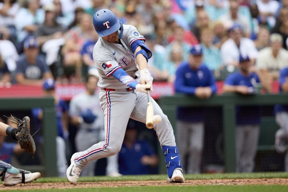 Texas Rangers' Kyle Higashioka singles in a run against the Seattle Mariners during the 10th inning of a baseball game Saturday, Aug. 2, 2025, in Seattle. (AP Photo/John Froschauer)