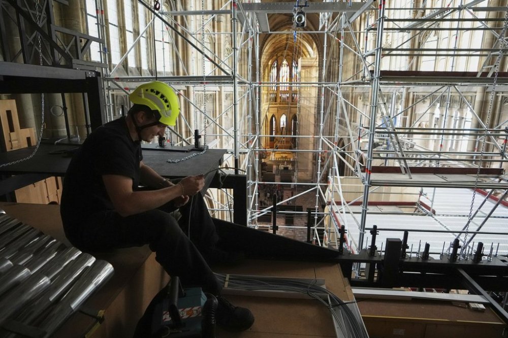 A worker adjusts cables during the installation of a new organ at Prague's St. Vitus Cathedral that is coming to its final stages in Prague, Czech Republic, Tuesday, July 22, 2025. (AP Photo/Petr David Josek)