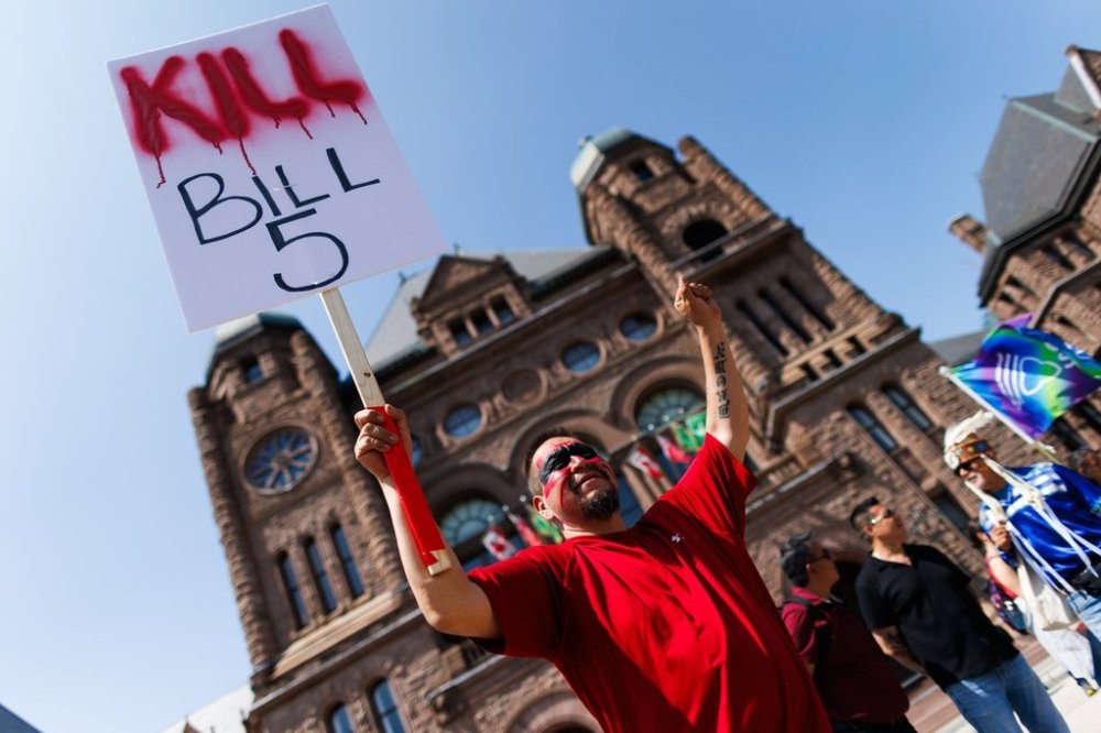 Protesters and community members chant and wave signs, as they listen to speakers during a demonstration opposing Bill 5, outside the Ontario Legislature at Queen's Park in Toronto, Monday, June 2, 2025. THE CANADIAN PRESS/Cole Burston