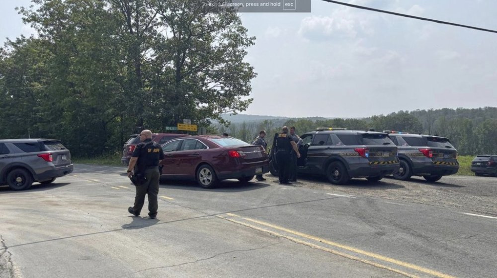 This image provided by WNEP shows police near the scene of a shooting where two state troopers were injured, Thursday, Aug. 7, 2025 near the village of Thompson in Susquehanna County, Pa. (WNEP via AP)