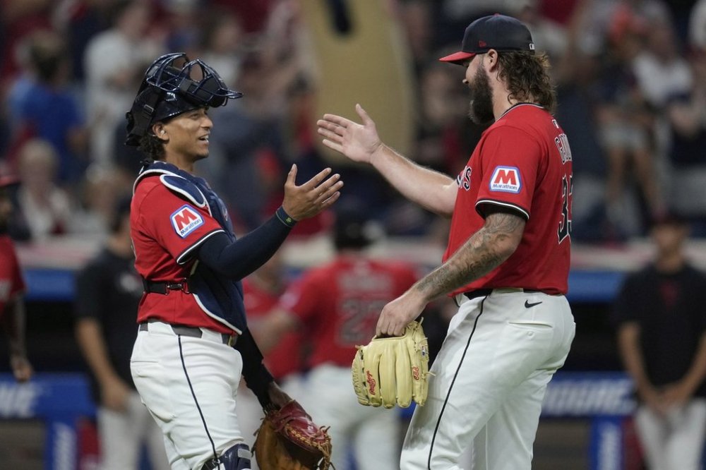 Cleveland Guardians catcher Bo Naylor, left, shakes hands with relief pitcher Hunter Gaddis, right, after the Guardians defeated the Baltimore Orioles in a baseball game in Cleveland, Monday, July 21, 2025. (AP Photo/Sue Ogrocki)