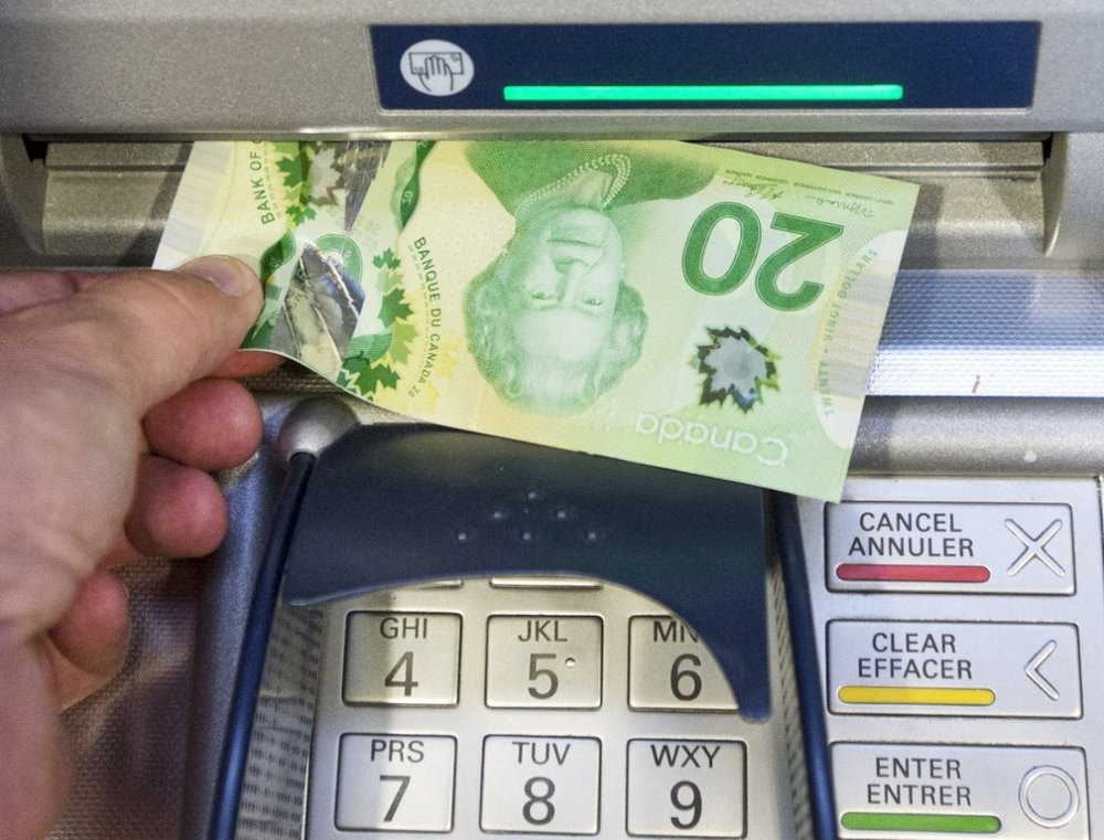 Ottawa is mulling raising the deposit insurance cap to $150,000. Money is removed from an ATM in Montreal, Monday, May 30, 2016. THE CANADIAN PRESS/Ryan Remiorz