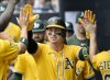 Athletics' Brent Rooker is greeted in the dugout after hitting a solo home run in the first inning of a baseball game against the Tampa Bay Rays, Wednesday, July 2, 2025, in Tampa, Fla. (AP Photo/Jason Behnken)