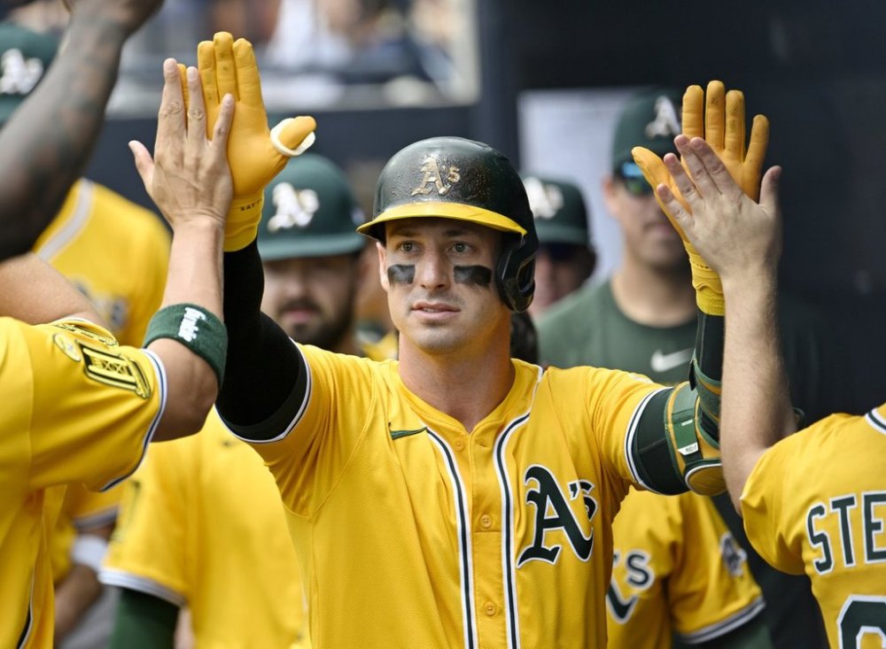 Athletics' Brent Rooker is greeted in the dugout after hitting a solo home run in the first inning of a baseball game against the Tampa Bay Rays, Wednesday, July 2, 2025, in Tampa, Fla. (AP Photo/Jason Behnken)