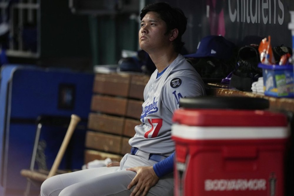 Los Angeles Dodgers' Shohei Ohtani sits in the dugout during the fourth inning of a baseball game against the Cincinnati Reds Wednesday, July 30, 2025, in Cincinnati. (AP Photo/Carolyn Kaster)