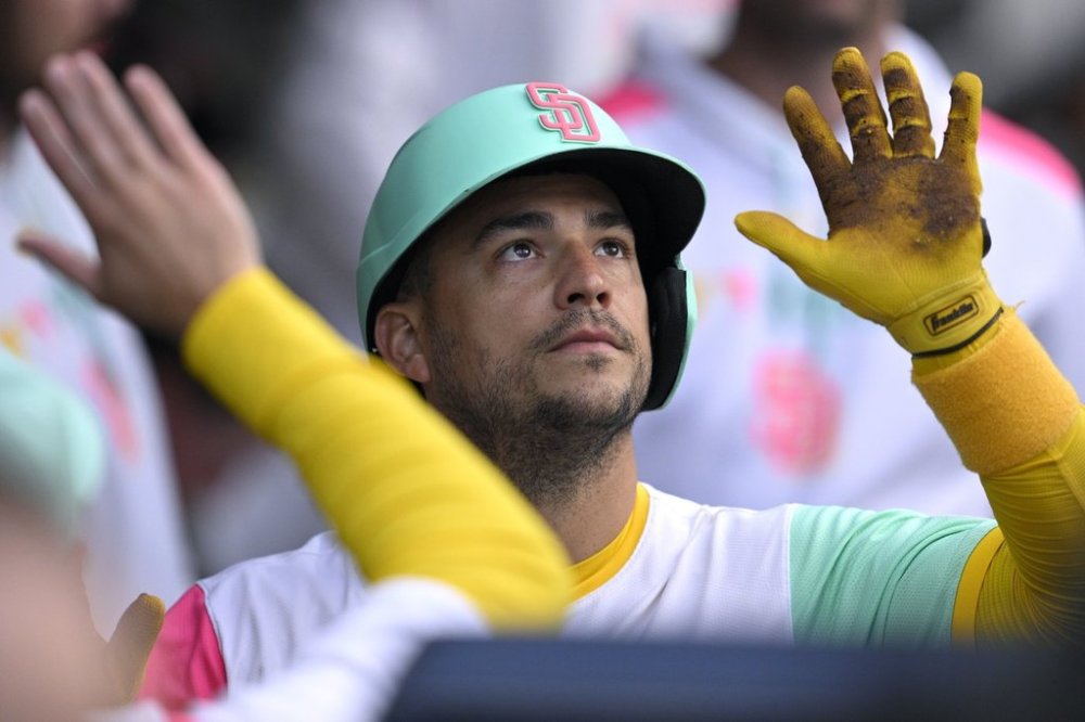 San Diego Padres' Jose Iglesias is congratulated in the dugout after scoring on a single by Fernando Tatis Jr. during the second inning of a baseball game against the Philadelphia Phillies, Friday, July 11, 2025, in San Diego. (AP Photo/Orlando Ramirez)