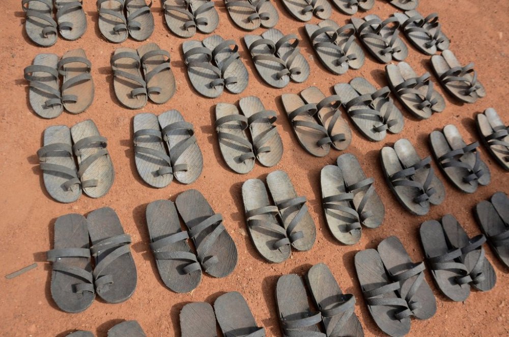 Footwear crafted from recycled rubber tires are displayed on the ground in Wau, South Sudan, Friday, June 13, 2025. (AP Photo/Michael Atit)