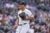 Colorado Rockies relief pitcher Seth Halvorsen, front, is escorted from the mound by head trainer Keith Dugger after throwing only five pitches to Pittsburgh Pirates pinch hitter Spencer Horwitz in the ninth inning of a baseball game Saturday, Aug. 2, 2025, in Denver. (AP Photo/David Zalubowski)