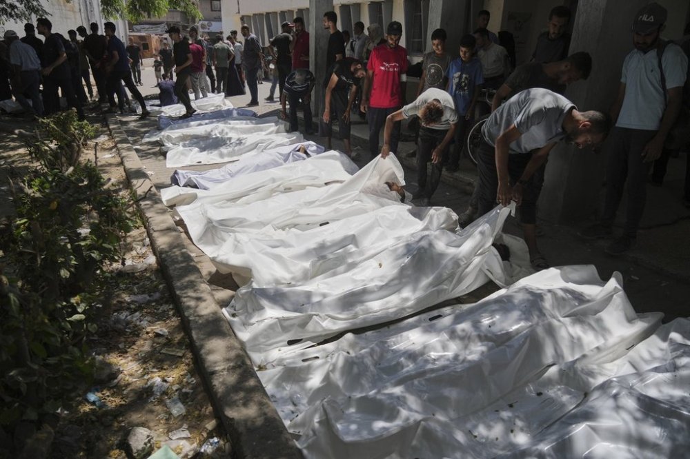 The bodies of Palestinians who were killed while attempting to access aid trucks entering northern Gaza through the Zikim crossing with Israel are brought to a clinic in Gaza City, Sunday, July 20, 2025. (AP Photo/Jehad Alshrafi)