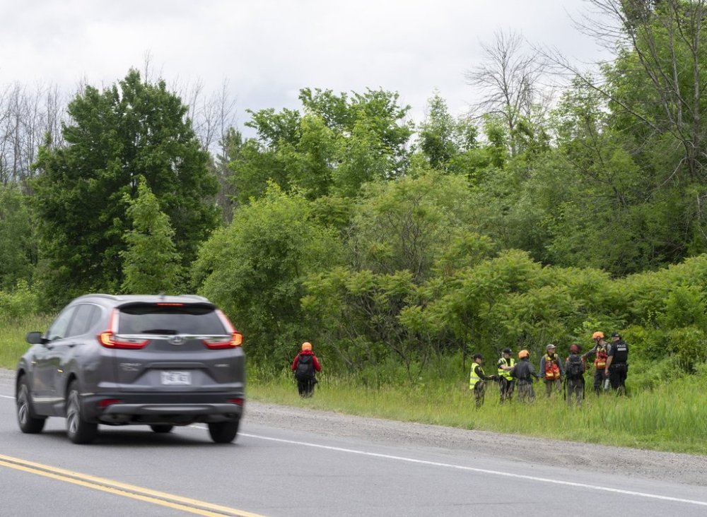 Police and rescue workers search the woods beside a highway for a missing three-year-old girl in Vaudreuil-Dorion, Que., Tuesday, June 17, 2025. THE CANADIAN PRESS/Christinne Muschi